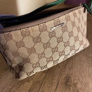 Classic Gucci design wristlet with green leather accent trim.